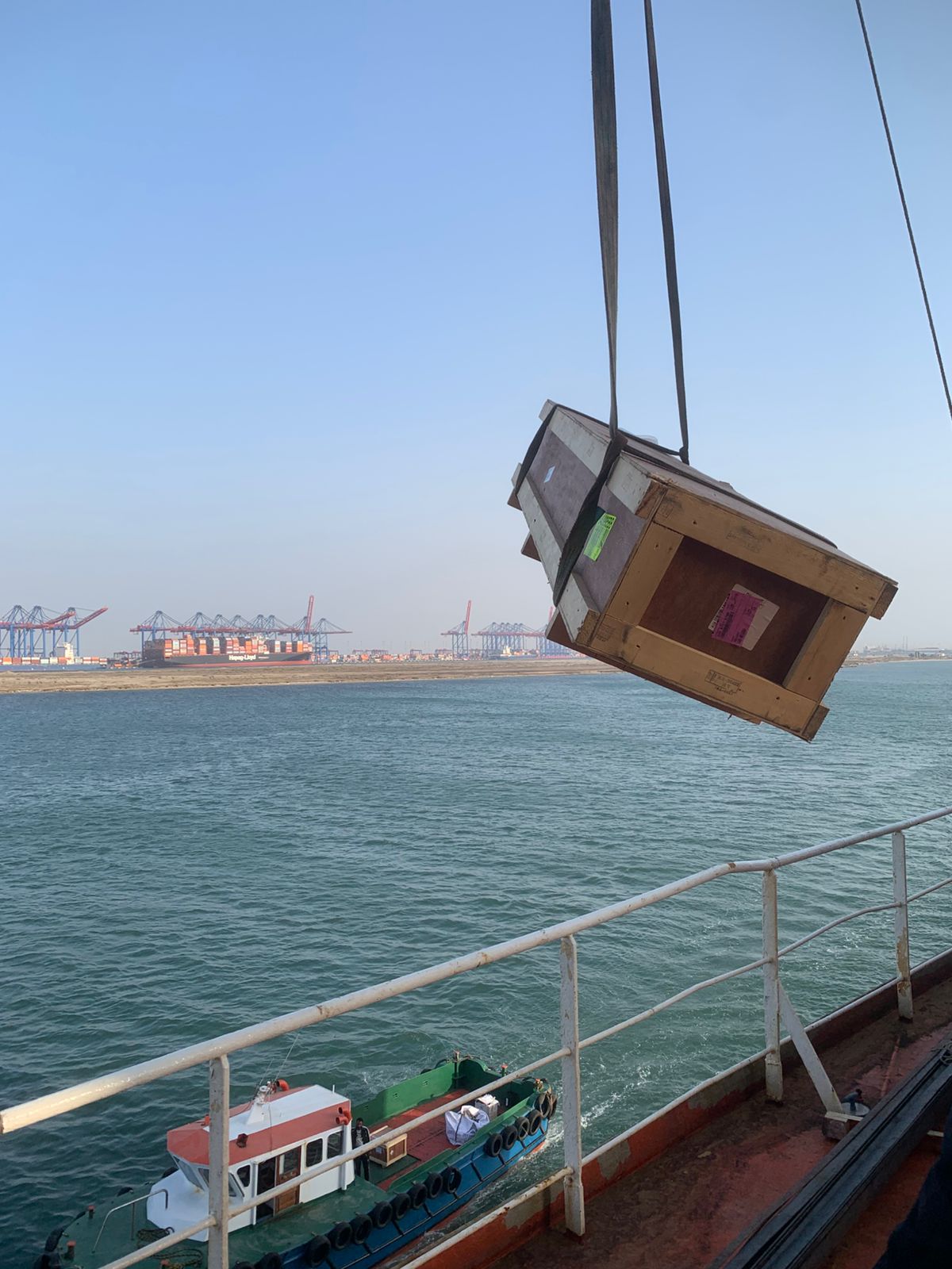 Cargo offloading operation at Port Said with container terminal in background